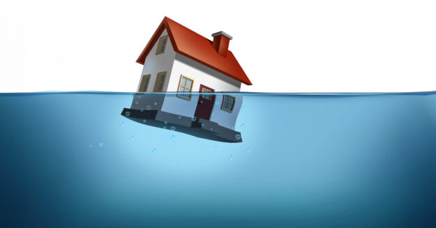 Ein Haus versinkt im Wasser – eine starke Metapher für Eigentümer in finanzieller Schieflage. Das Bild steht sinnbildlich für den drohenden Verlust der Immobilie durch Zwangsversteigerung und verdeutlicht die Dringlichkeit rechtzeitigen Handelns | Zwangsversteigerung bei Immobilien vermeiden
