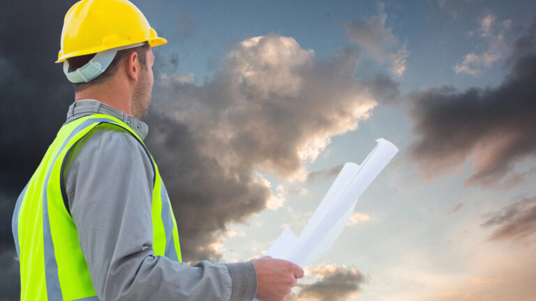 Neubau in der Krise ein Bauarbeiter vor einer Gewitterwand; als symbol für eine Krise im Neubau