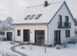 Modernes Einfamilienhaus in verschneiter Winterlandschaft; symbolisiert den Immobilienverkauf in der kalten Jahreszeit und die Chancen einer gelungenen Präsentation im Winter. | Immobilienverkauf