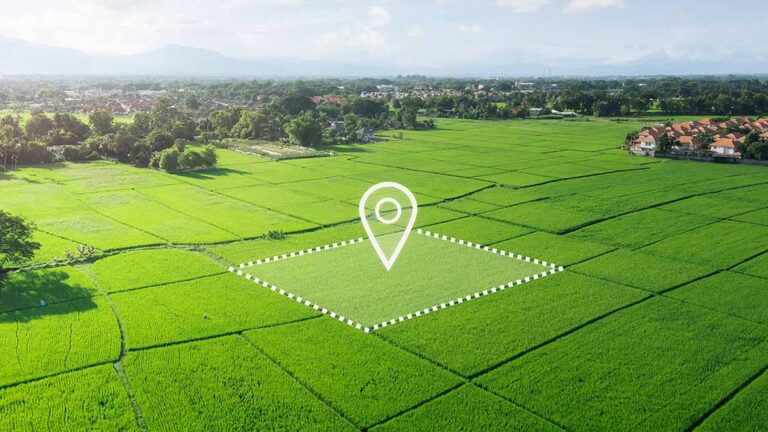 Grundstücksverkauf Luftaufnahme eines unbebauten, grünen Grundstücks mit markierter Fläche und Standort-Symbol, das die Entwicklungsmöglichkeiten und den gezielten Verkauf von Bauland veranschaulicht. | Grundstücksverkauf